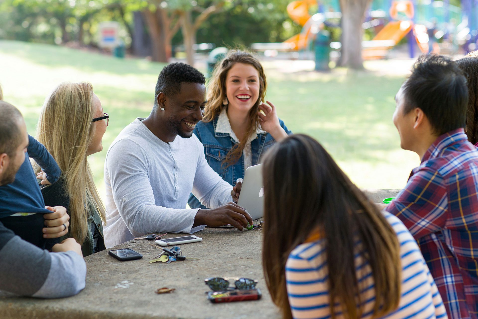 Community-Driven Growth Creates Long-Term Business Value Diverse group of people gathered outdoors around a table sharing ideas and conversations, representing how strong communities build trust, collaboration, and sustainable business growth over time.
