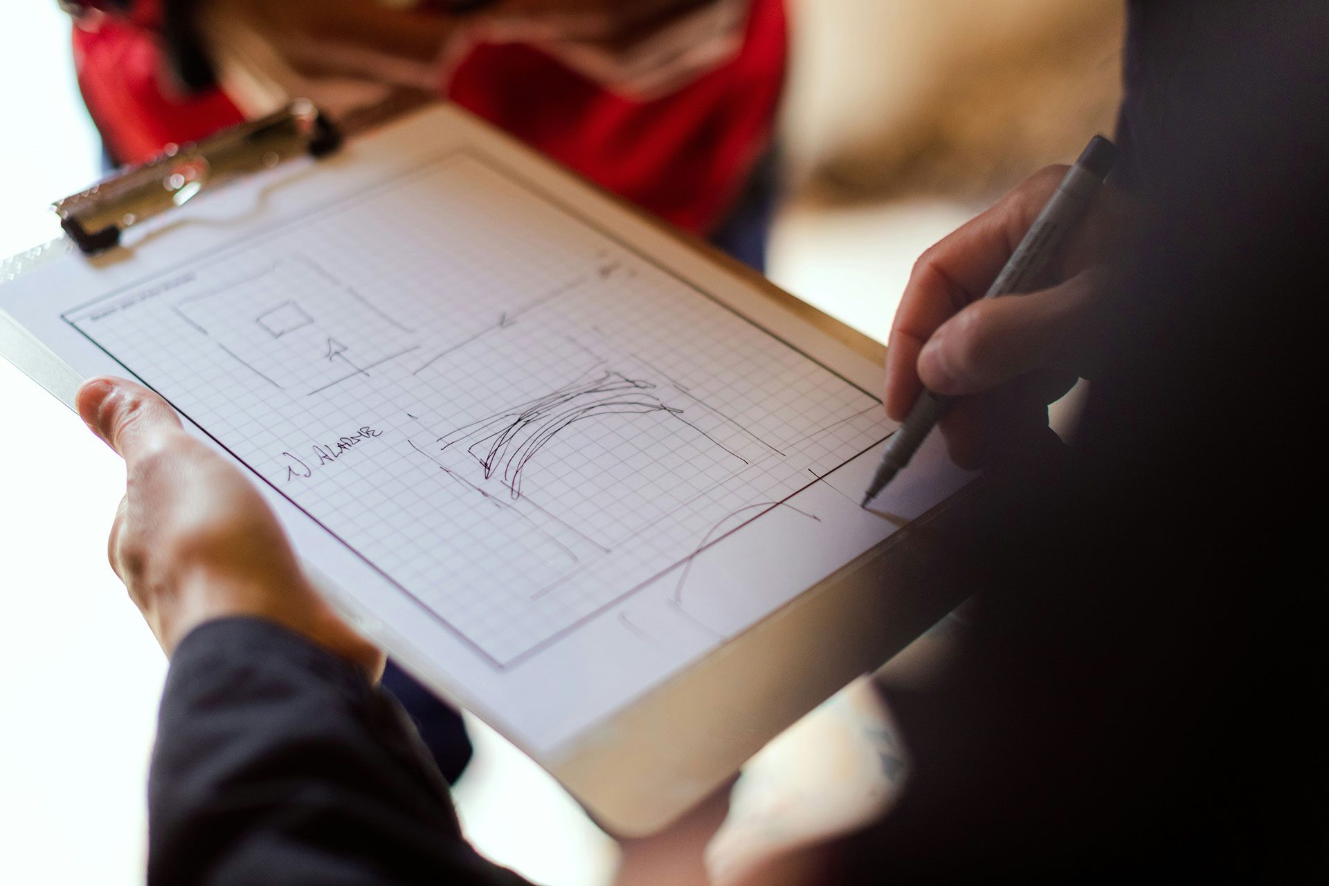 Designing Repeatable Systems for Scalable Growth Business professional sketching workflow diagrams and process structures on a clipboard, representing the transformation of individual skills into repeatable systems and scalable intellectual property.