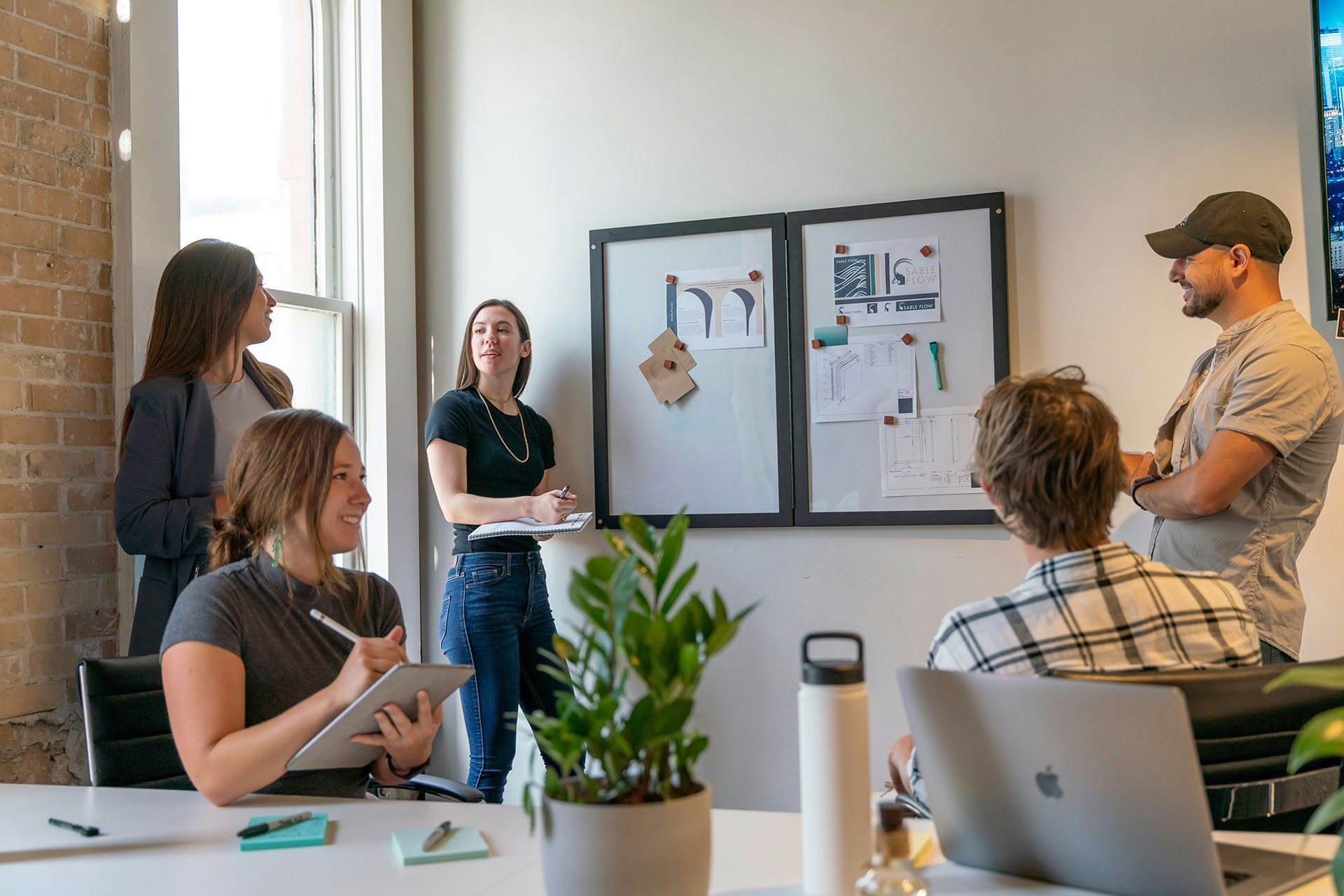 Team discussing brand and design materials during a business meeting, representing how SMEs can turn founder-led knowledge into structured systems, intellectual property, and tradeable business assets.
