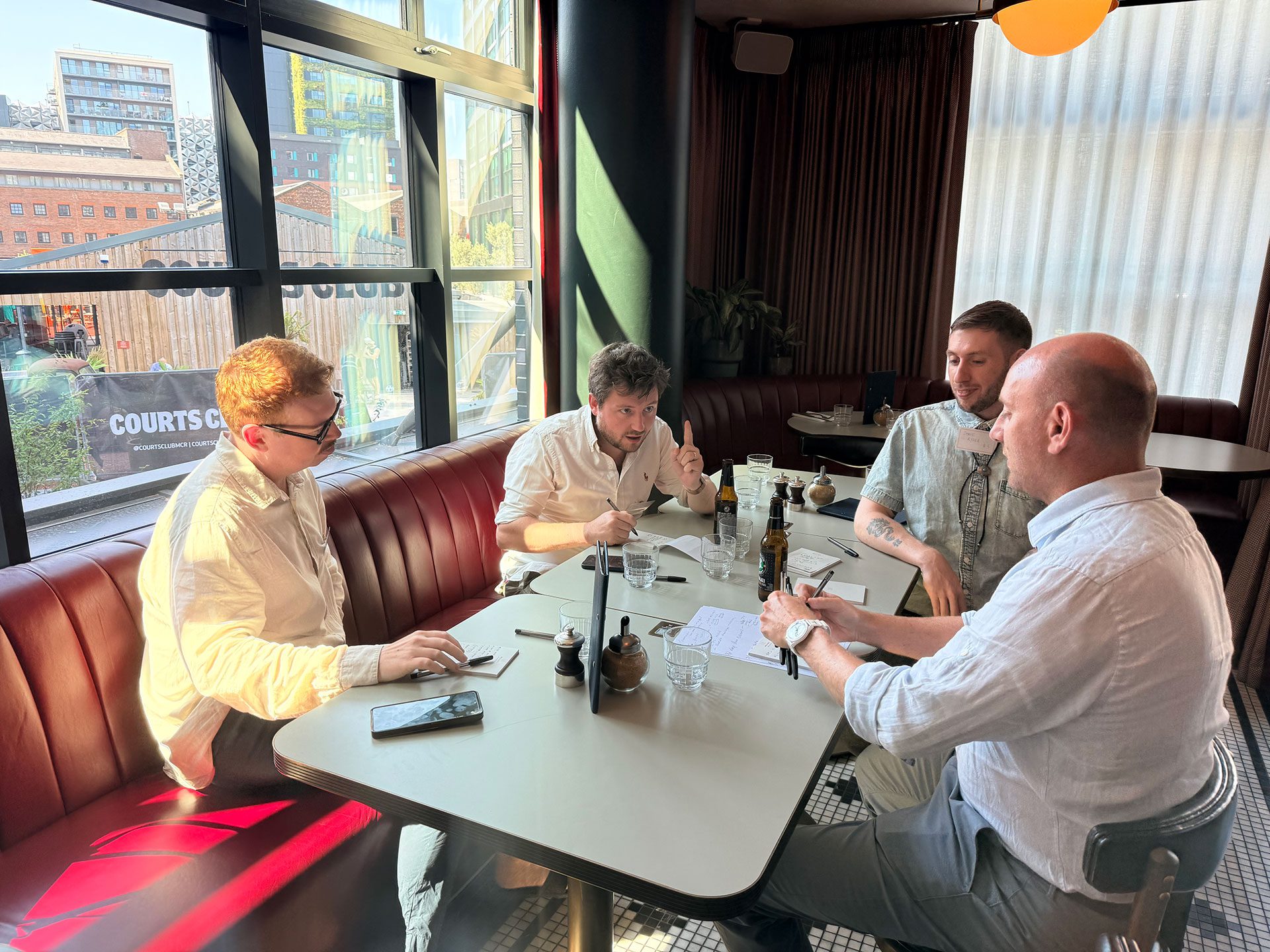 Four SME founders in a collaborative workshop discussing business growth, intellectual property and new revenue opportunities.